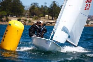 Sailboat racing at Woollahra Sailing Club with sailors navigating around a buoy.