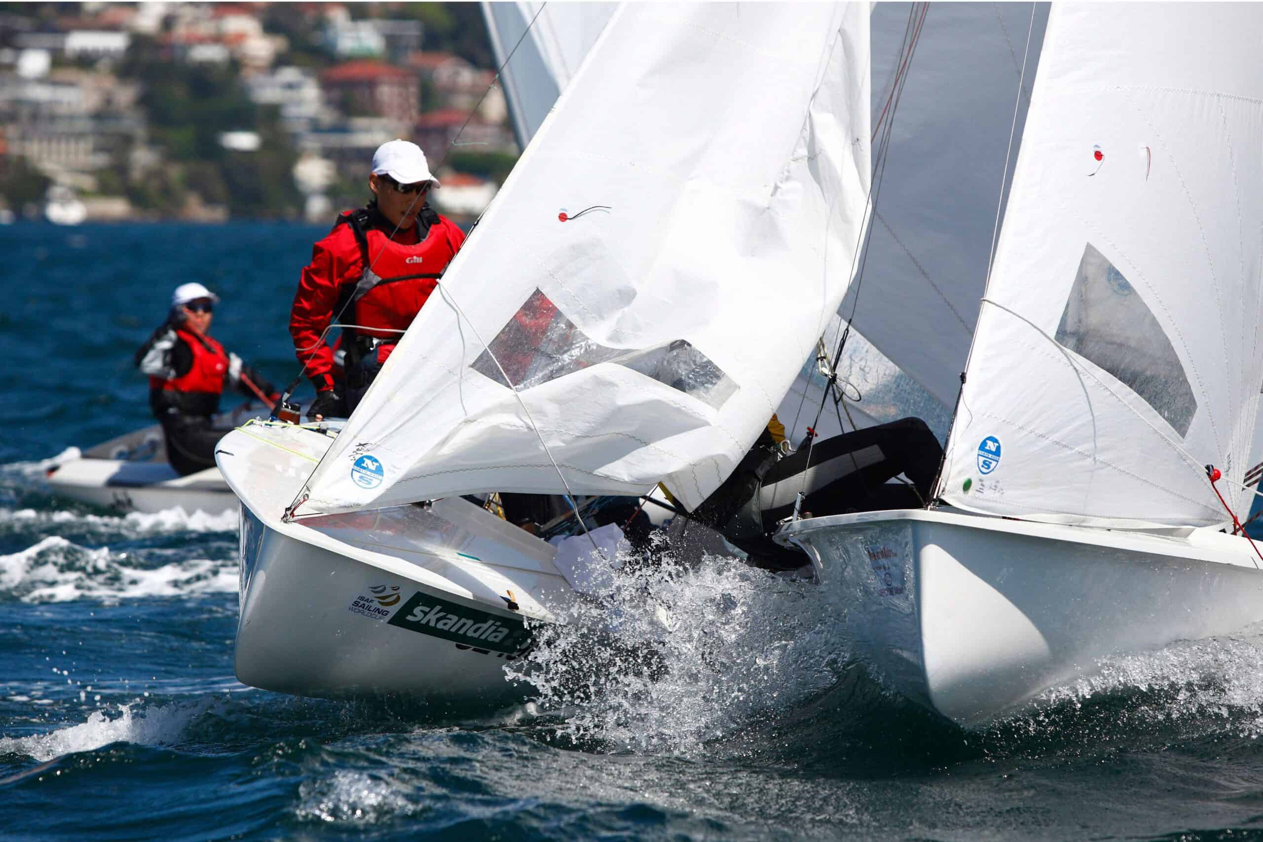 Sailing boats racing at Woollahra Sailing Club with crew members in red jackets.
