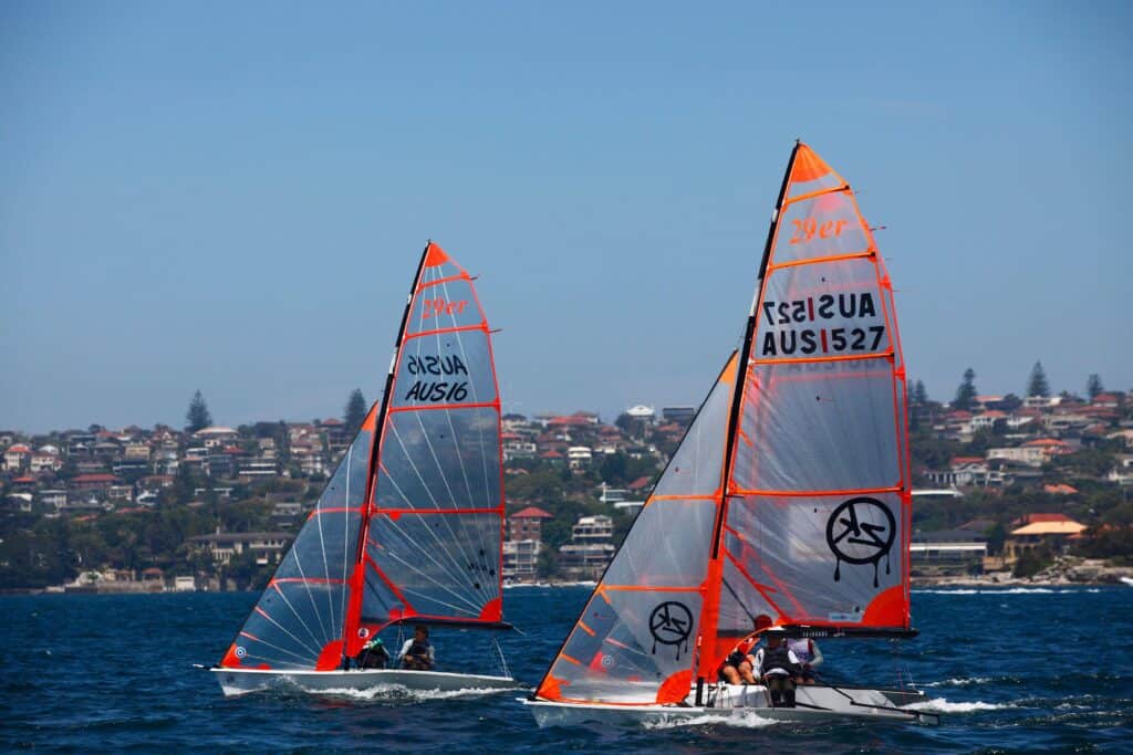 Sailing boats with orange sails on Sydney Harbour near Woollahra.
