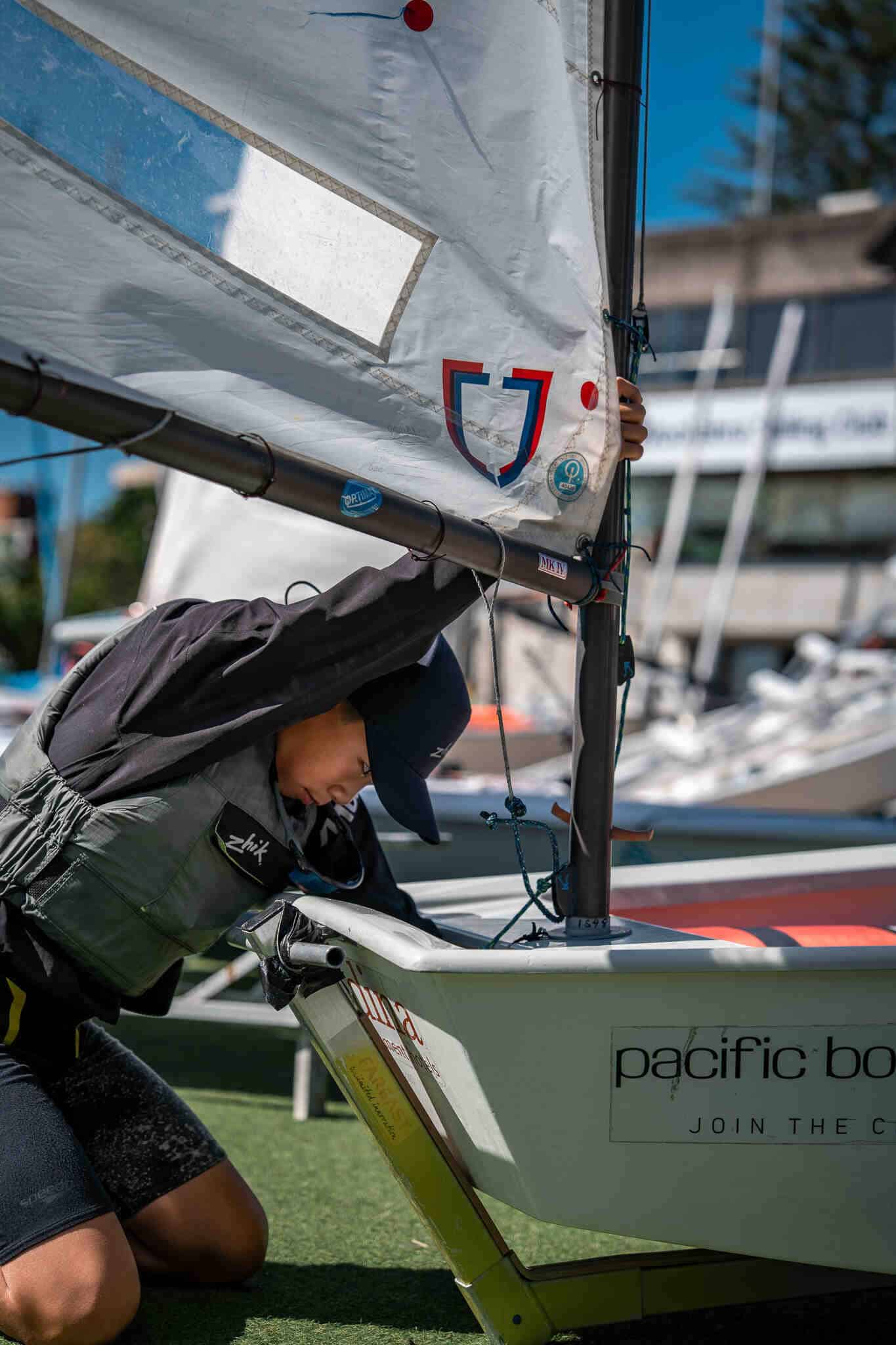 Young sailor adjusting sail at Woollahra Sailing Club in Sydney.