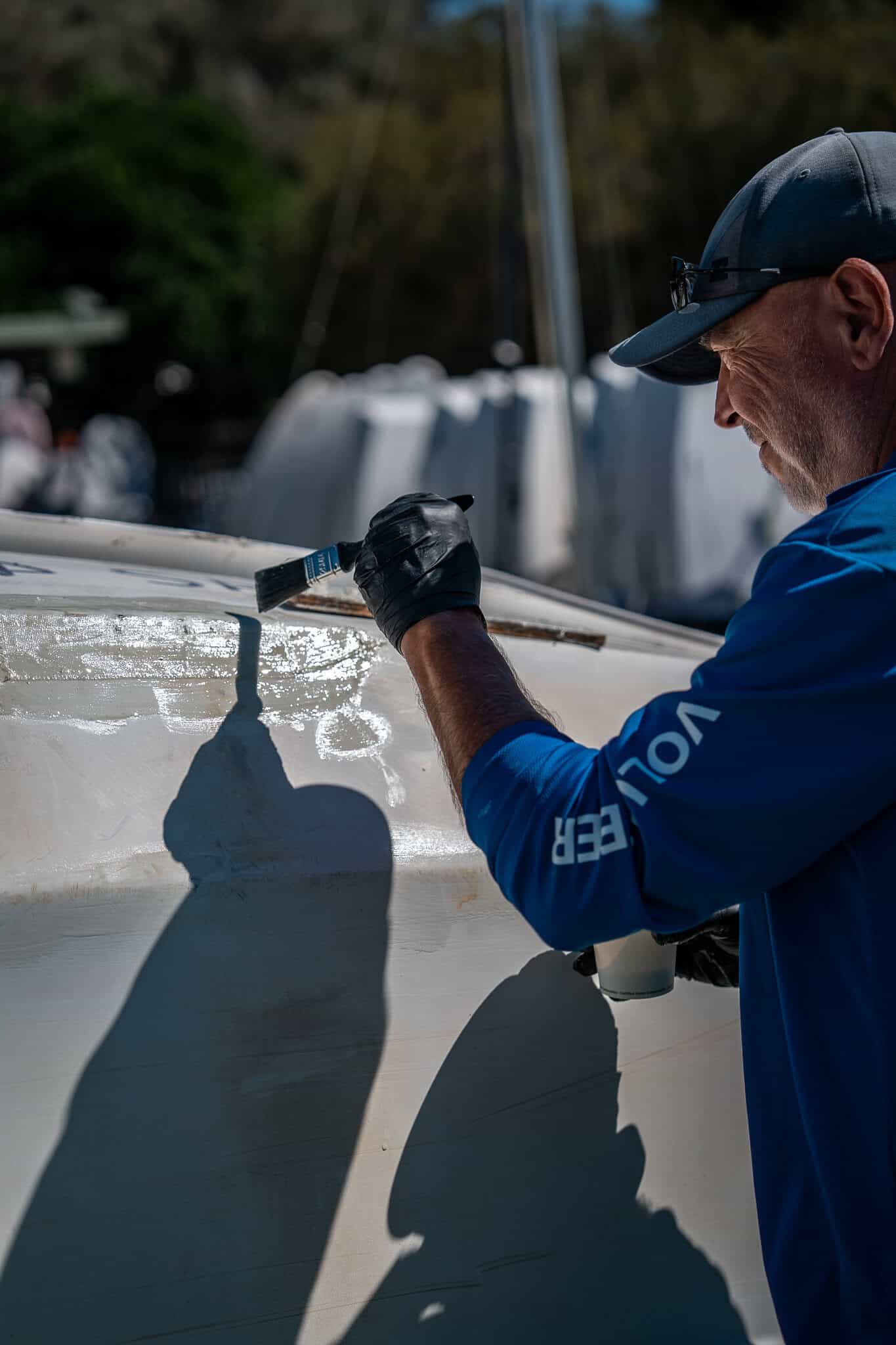 Man repairing a boat at Woollahra Sailing Club in Australia.