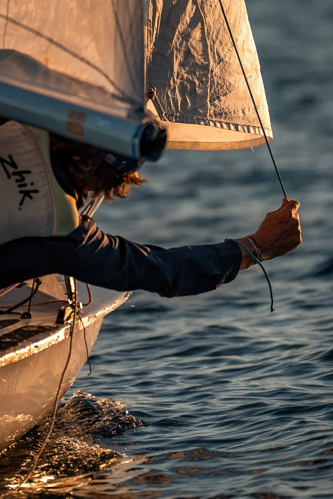 Sailor adjusting the sail on a boat at Woollahra Sailing Club.