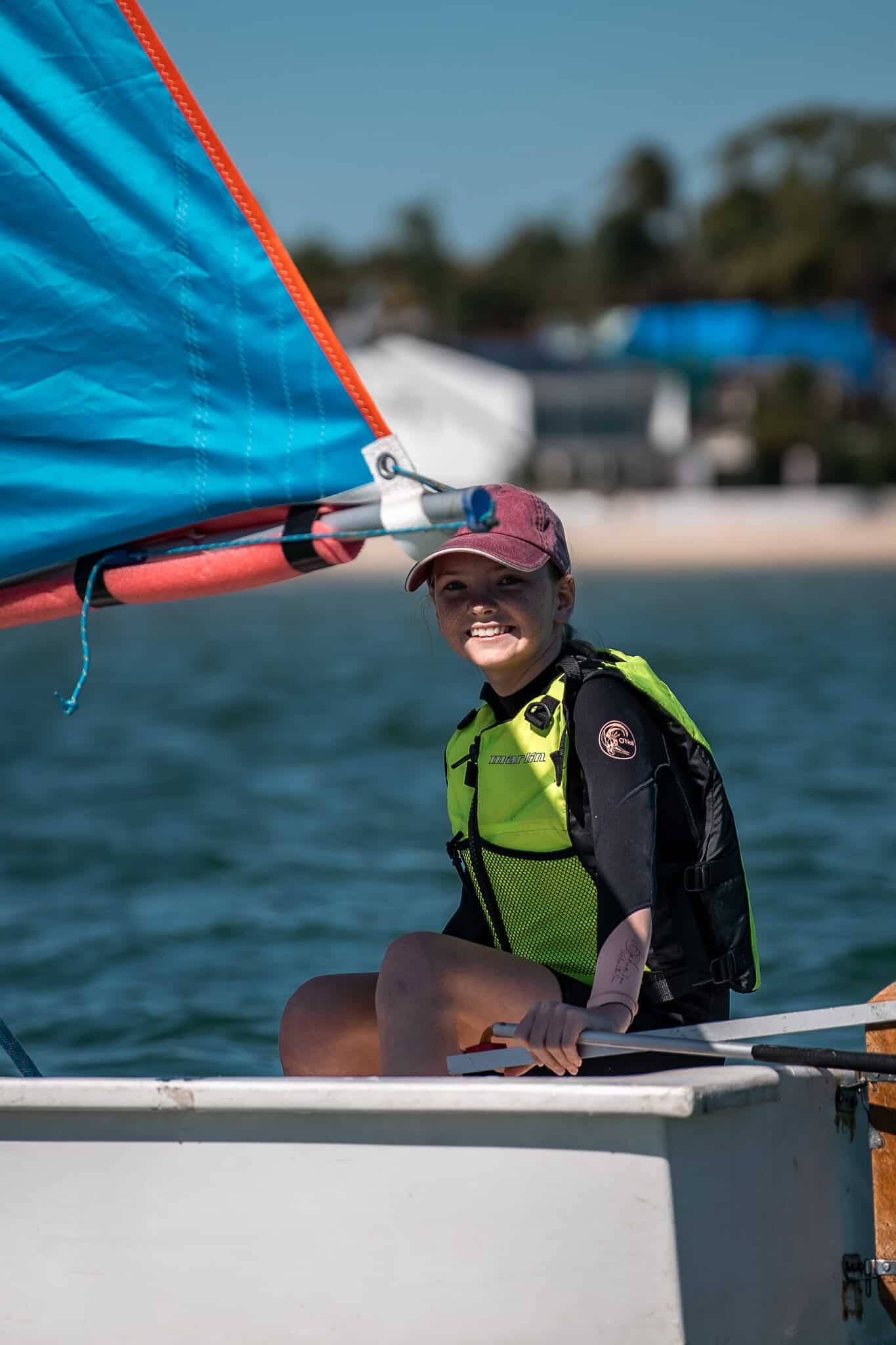Young sailor smiling on a boat at Woollahra Sailing Club, Australia.