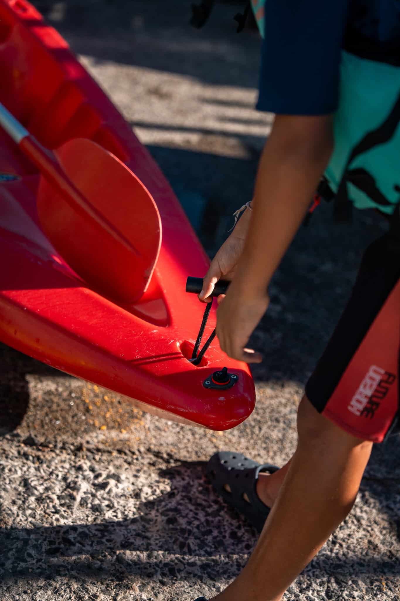 Person preparing a red kayak at Woollahra Sailing Club in Australia.